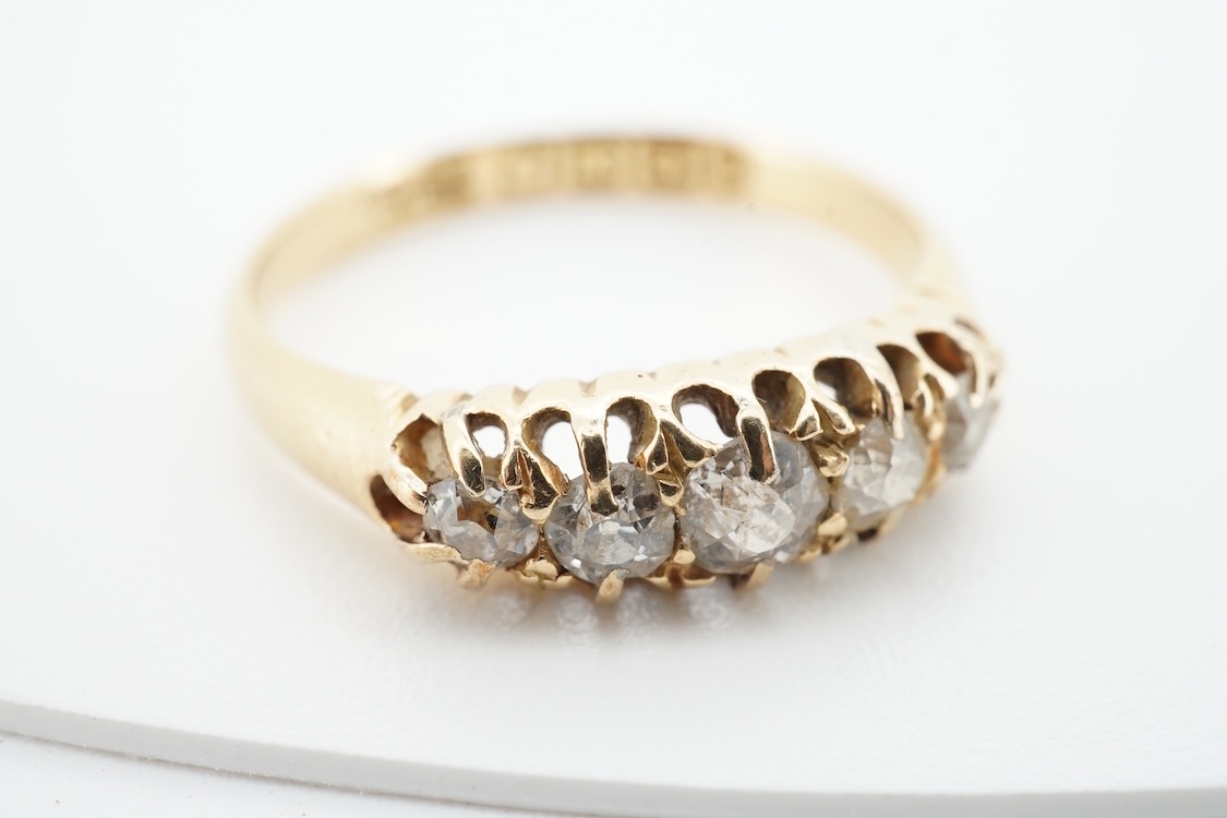 A late Victorian 18ct gold and graduated claw set five stone diamond ring, size N, gross weight 2.8 grams.